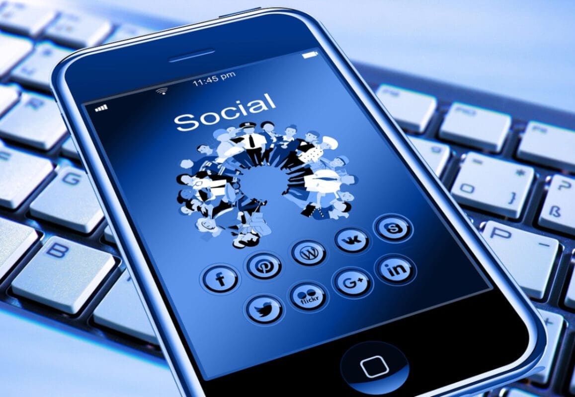 A smartphone on a computer keyboard showing social media icons showing local web designer in Monmouth County