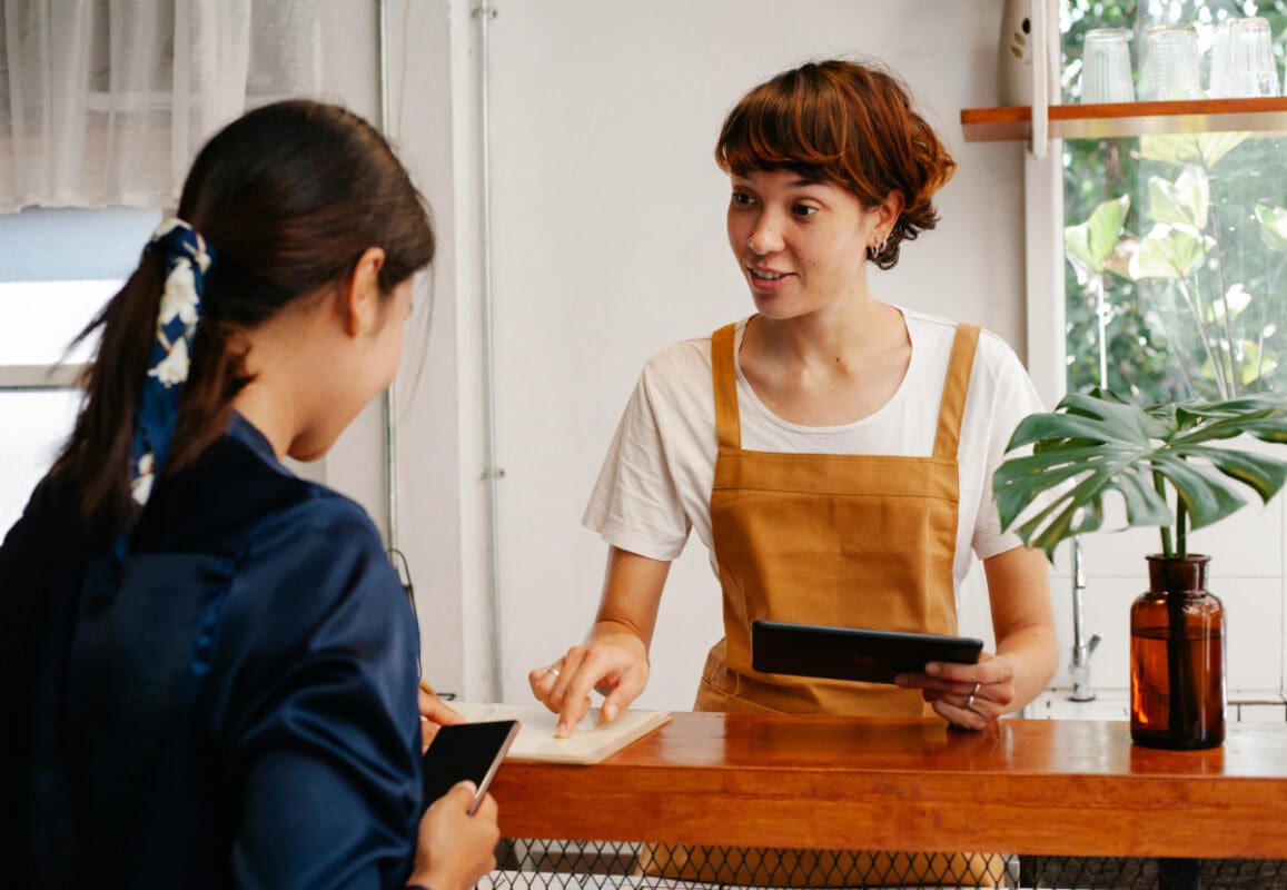 Two women looking at tablet and phone looking for a web designer for their business